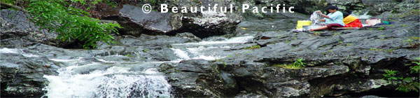 fijian women washing clothes in waterfall in taveuni island