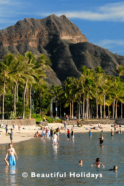 tourists enjoying the water beside diamond head at famous waikiki beach hawaii