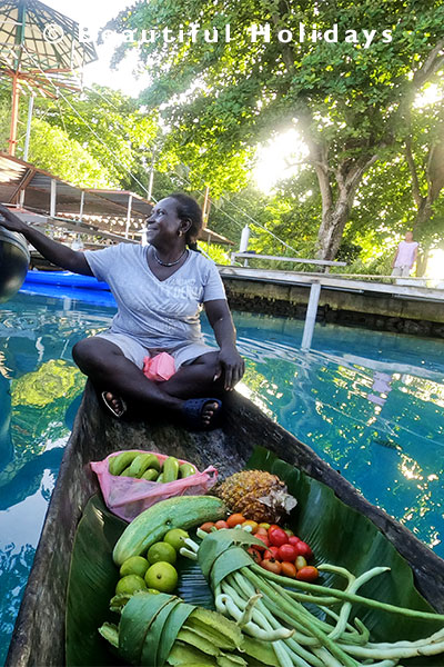 local selling vegetables from dugout canoe in the solomon islands